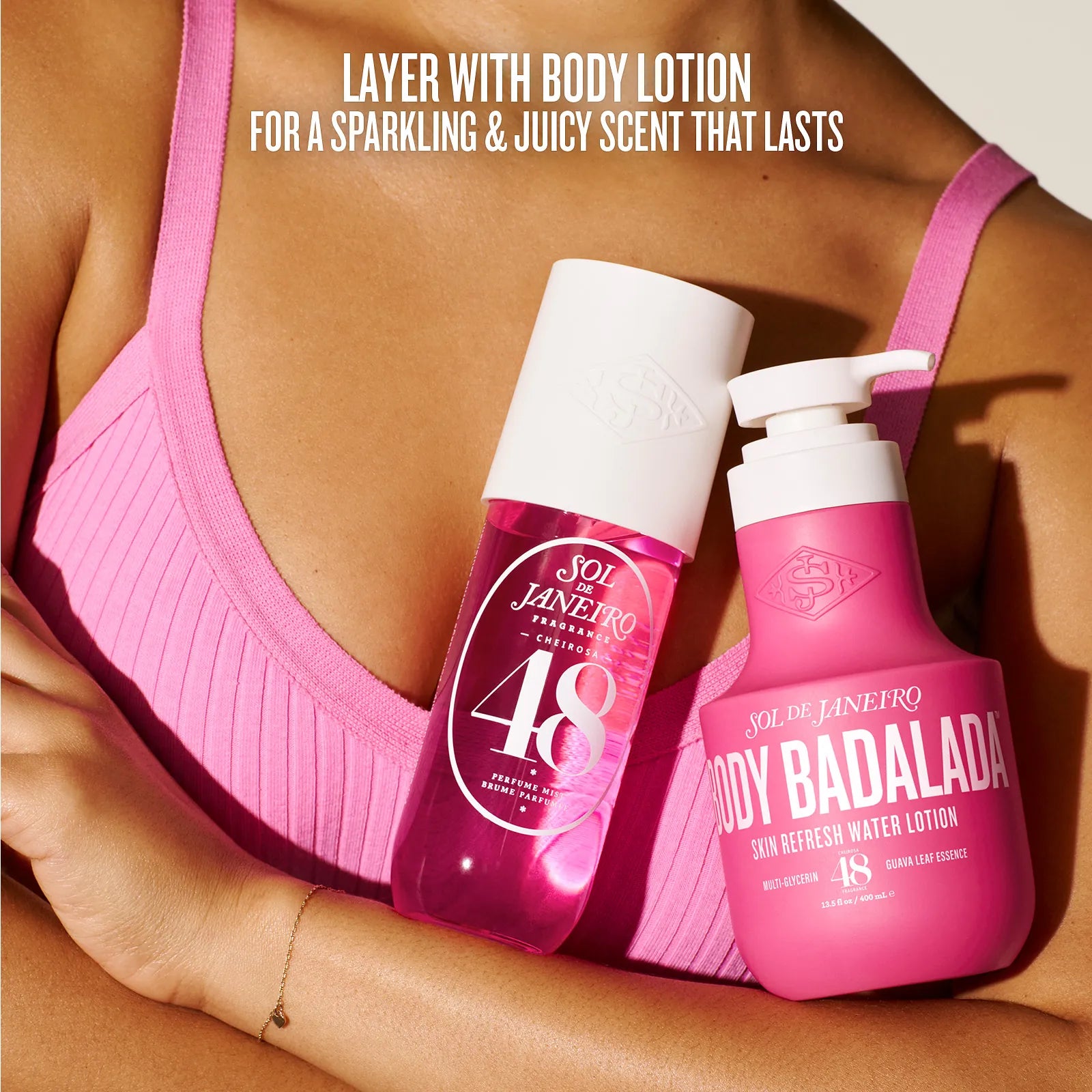 Two bottles of 'Sói de Janeiro' body lotion held by a person wearing a pink bra.